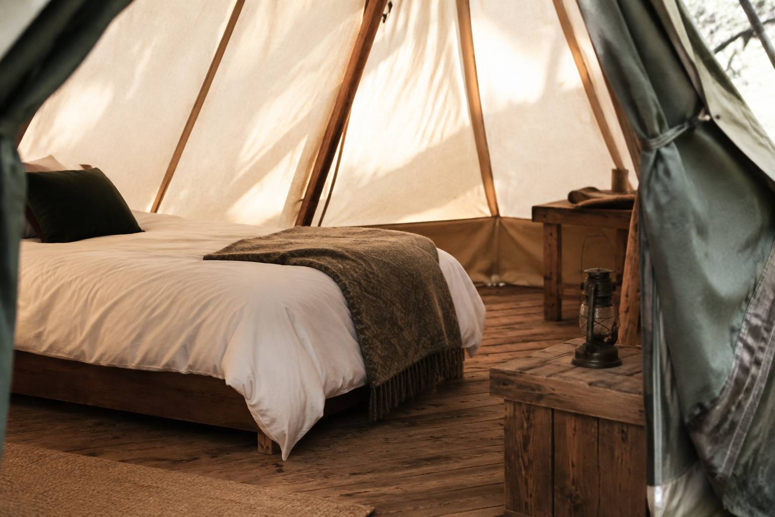 Intérieur de tente de glamping avec lit fait et petite table en bois